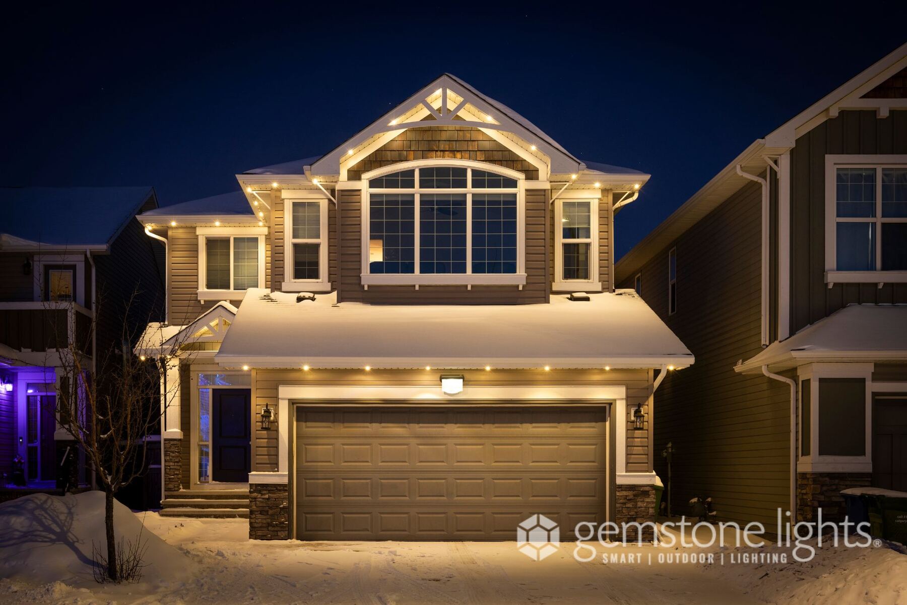 The same home at night with warm white permanent lights on